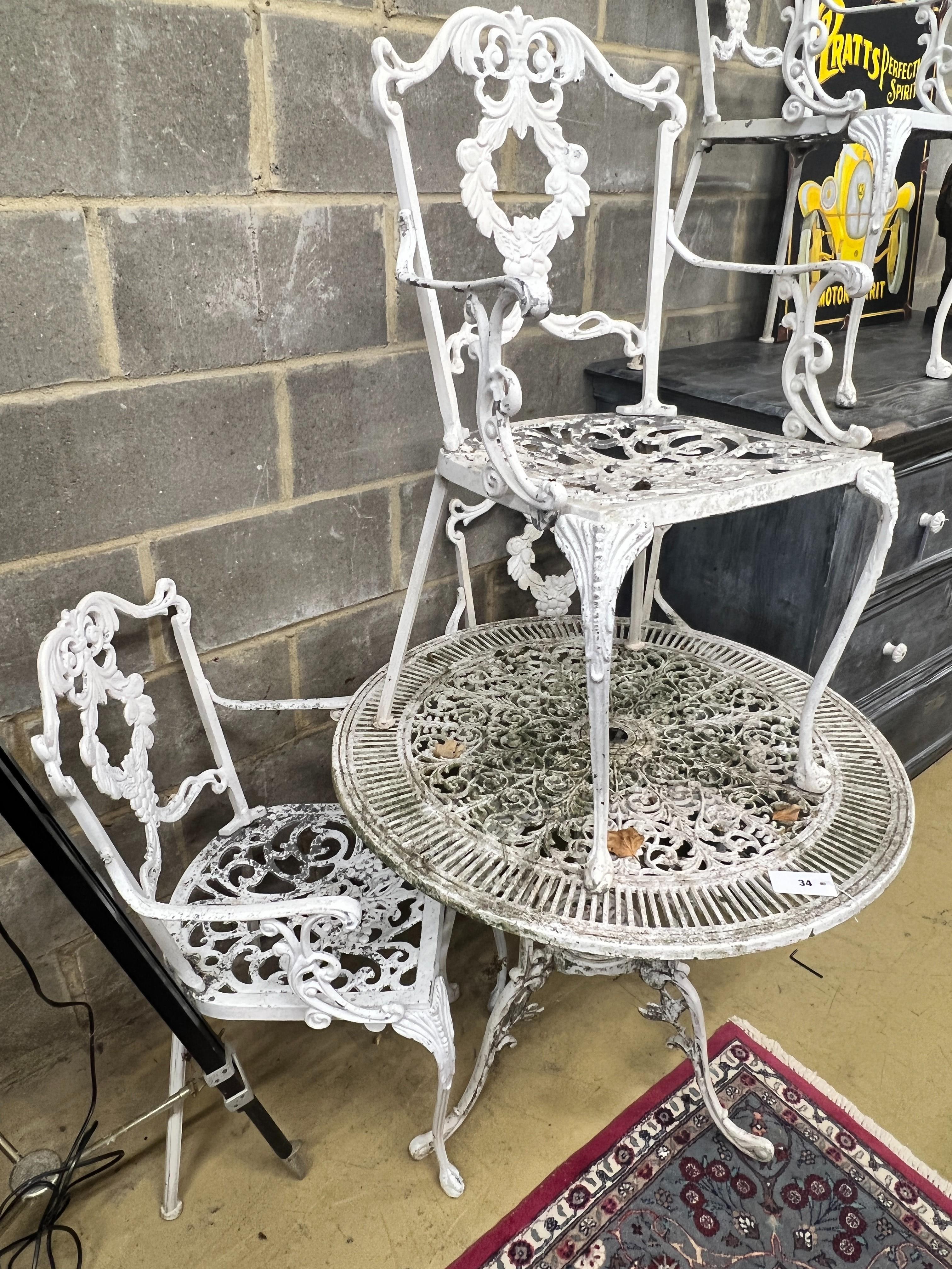 A circular painted aluminium garden table, diameter 80cm, height 70cm together with four elbow chairs